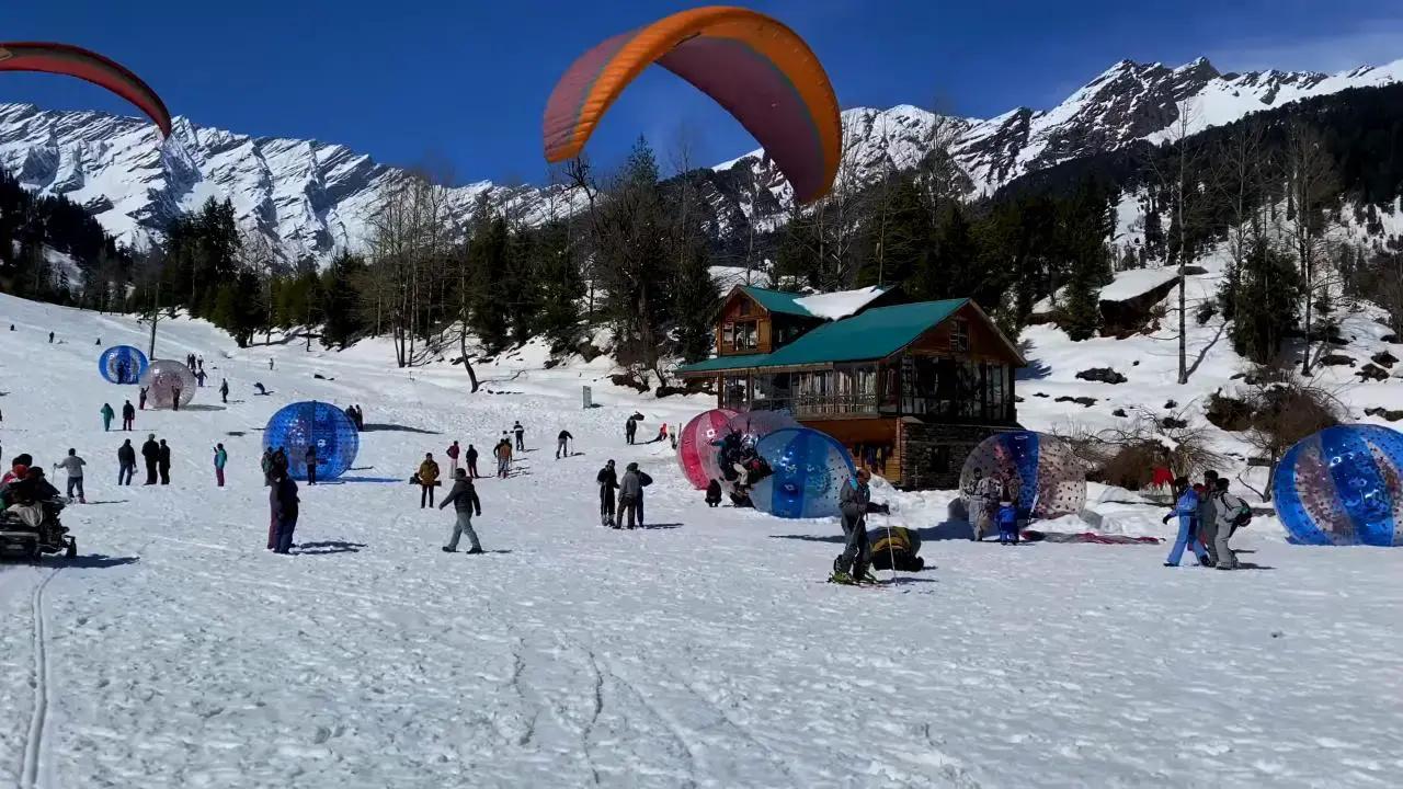 Travelers enjoying adventure activities in Manali surrounded by beautiful Himalayan mountains