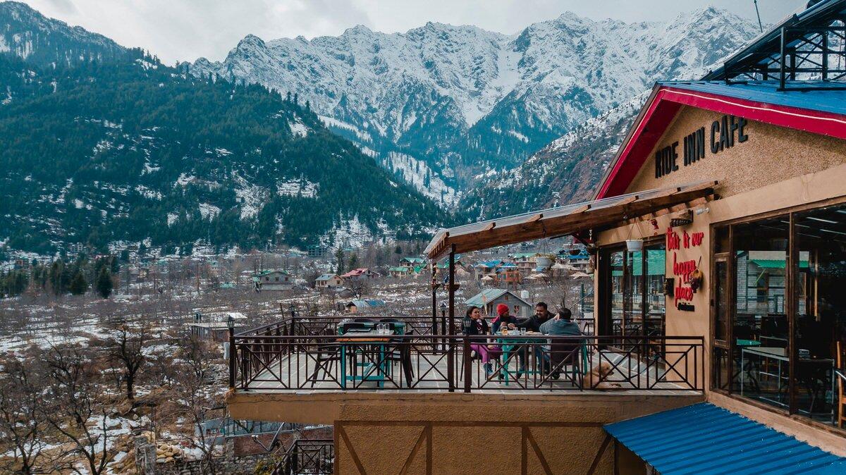 Travelers enjoying the peaceful atmosphere and mountain views in Old Manali